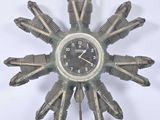 a clock made out of old motorcycle parts on a white surface
