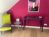 a purple table and a green chair in the corner of a room