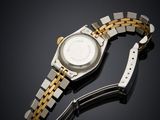 a close up of a watch on a black surface with a black background