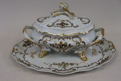 un plateau blanc et doré sur lequel sont posés une tasse et une soucoupe