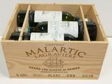 bottles of wine are in a wooden box on a table