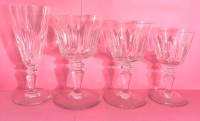 quatre verres à vin sont alignés sur un plateau rose