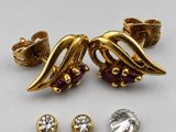 two pairs of gold tone earrings and a pair of garnets