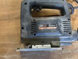 an electric jig saw sitting on top of a wooden table