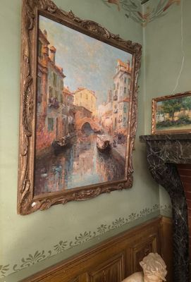 a painting on the wall above a fireplace in a room