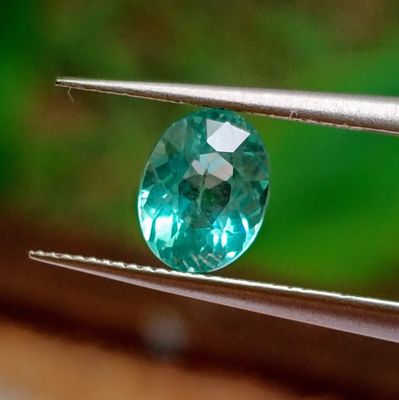 an image of a close up of a blue diamond being held by a pair of pliers