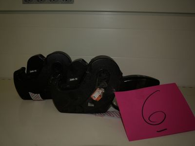 a pink sign on the counter next to a pair of black shoes