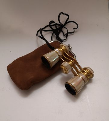 an old pair of binoculars sitting on top of a brown bag