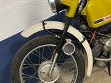 a yellow and black motorcycle parked next to a blue and white wall