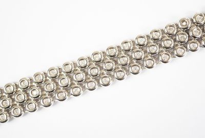 gros plan d'un bracelet en argent sur une surface blanche