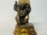 une statue en bronze représentant un homme tenant un verre