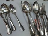 a lot of silver spoons and forks on the table
