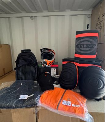 many bags of luggage sitting on top of a cardboard box