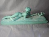 a small statue of a boy laying on a surfboard