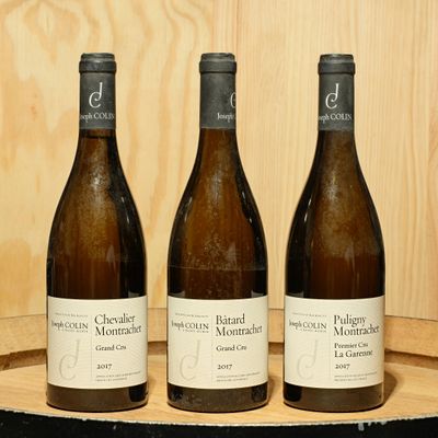 trois bouteilles de vin posées sur un tonneau en bois