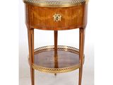 une table d'appoint avec un plateau en verre et une plaque en laiton sur le dessus