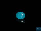 a close up of a blue diamond on a black surface