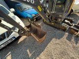 a small excavator that is sitting in the gravel