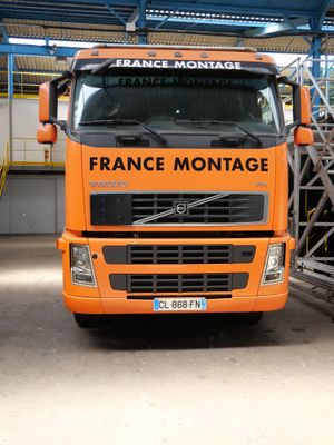 un gros camion orange garé dans un garage
