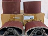 three sanding belts are sitting on top of boxes of sand