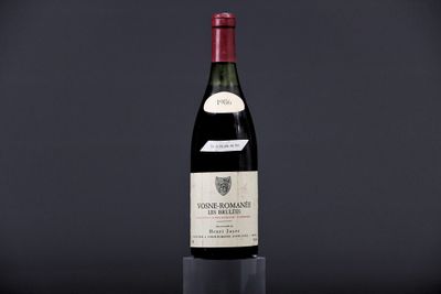 a bottle of wine sitting on top of a table next to a glass