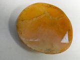 a close up of a yellow stone on a white surface