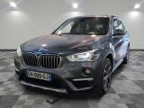 the bmw x1 is parked in a showroom with a checkered floor