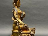 an image of a statue of a woman sitting on top of a table