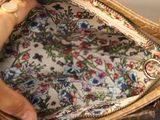 a woman holding a purse with a floral pattern