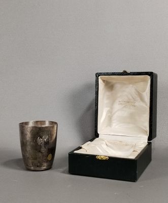 a silver cup sitting next to a silver cup on a table