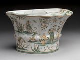 a white vase with green and yellow designs on it