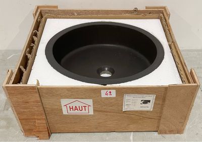 un évier noir posé dans une caisse en bois posée par terre