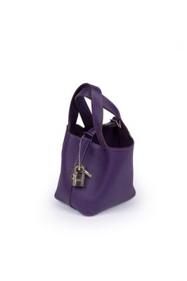 sac à main violet sur fond blanc, avec une clé au milieu