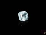 a close up of a blue diamond on a black surface