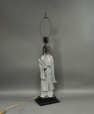 a white statue of a man with a lamp on top of a table