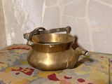 un petit pot en laiton posé sur un coussin