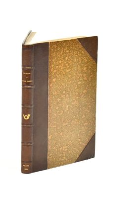 an old book with a brown cover sitting on top of a white surface