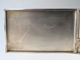 an antique silver cigarette case with writing on the inside