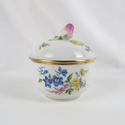 un petit bol blanc orné de fleurs bleues et jaunes