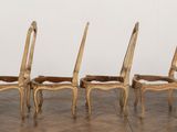 four wooden chairs are lined up in a row on a tile floor