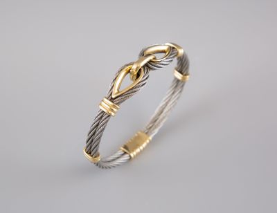 a close up of a silver and gold bracelet on a white background