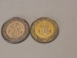 two coins with the initials of two different countries on them