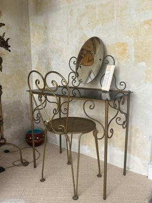 une table avec un miroir et une chaise dans une pièce