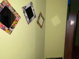 a suitcase sitting in the corner of a room with pictures on the wall