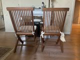 two wooden chairs sitting next to each other in a room