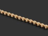 a close up of a gold bracelet on a black background
