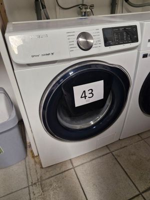 une machine à laver et un sèche-linge dans une pièce au sol carrelé