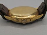 a close up of a gold watch with a leather band