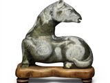 sculpture of a horse on a wooden base on a white background