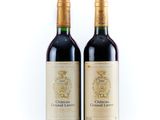 two bottles of wine sitting next to each other on a white surface